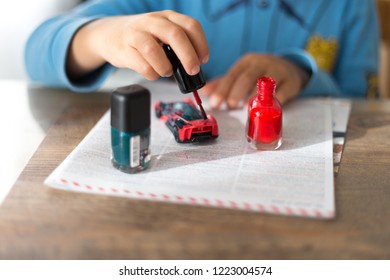 The Child Covers The Car With Varnish. Nail Polish