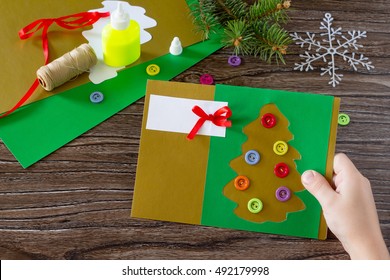 The Child Create Christmas Greeting Cards Paper Festive Fir In Christmas Tree Toys. Made With His Own Hands. Children's Art Project, Needlework, Crafts For Children. Craft For Kids.