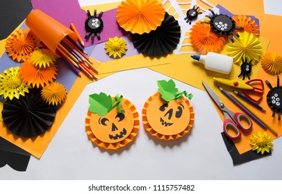 The child creates a hand-crafted pumpkin. Children's hands. Gift box for a party of Halloween. Craft for kids. Education school kindergarten. Pumpkin made of paper. Materials for creativity.