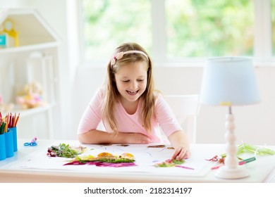 Child Creating Picture With Colorful Leaves. Art And Crafts For Kids. Little Girl Making Collage Image With Rainbow Plant Leaf. Biology Homework For Young School Student. Creative Autumn Home Fun.