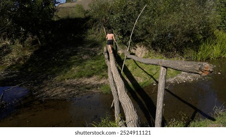 Child crosses a makeshift wooden bridge                              - Powered by Shutterstock