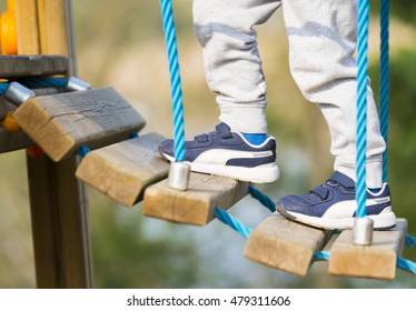 Child Crossing The Rope Bridge At The Park