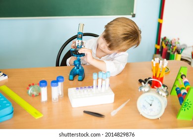 Child With Curiosity During A Medicine Fair Looking At Bacteria Through A Microscope And Learning Science. Back To School Concept