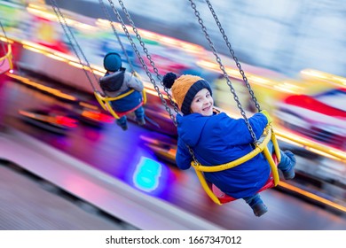 Child, cute boy riding chain swing carousel on sunset, motion blur, colorful background