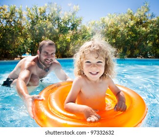 Child With Dad Playing In Pool. Summer Vacations