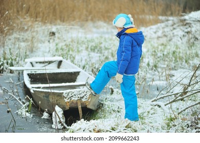 A Child In Danger On Thin Ice In Winter. The Boy Is Ice Skating On A Frozen Lake.