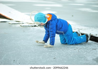 A Child In Danger On Thin Ice In Winter. The Boy Is Ice Skating On A Frozen Lake.