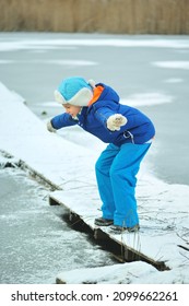 A Child In Danger On Thin Ice In Winter. The Boy Is Ice Skating On A Frozen Lake.