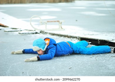 A Child In Danger On Thin Ice In Winter. The Boy Is Ice Skating On A Frozen Lake.