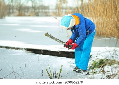 A Child In Danger On Thin Ice In Winter. The Boy Is Ice Skating On A Frozen Lake.