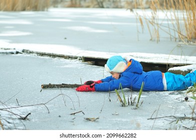 A Child In Danger On Thin Ice In Winter. The Boy Is Ice Skating On A Frozen Lake.