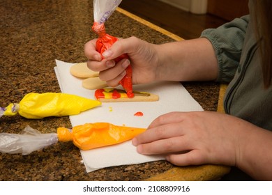 Child Decorating Sugar Cookies With Autumn Colored Icing