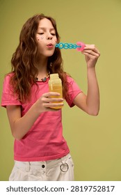 Child delightfully blows bubbles while wearing comfy and cute clothing, filled with joy.