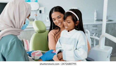 Child, dentist or education of brushing teeth in office or family friendly demonstration of tooth hygiene. Girl, parent or pediatric orthodontist with dental model to brush or lesson on mouth care - Powered by Shutterstock