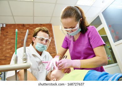 Child Dentist Treat Boy Teeth Under Sedation With Dental Curing Ultraviolet Light Equipment