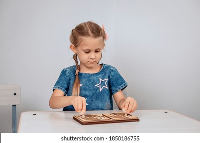 Child Development. Young Bright Focused Female Kid Sitting At The Table And Solving Brain Development Puzzle. Progress Concept