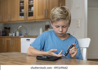 Child With Diabetes Measuring Glucose Or Blood Level In A Kitchen.