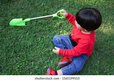 A Child Digging Soil On The Ground