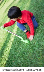 A Child Digging Soil On The Ground