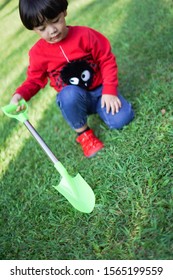 A Child Digging Soil On The Ground