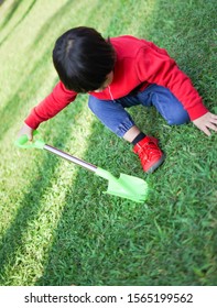 A Child Digging Soil On The Ground