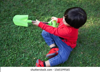 A Child Digging Soil On The Ground