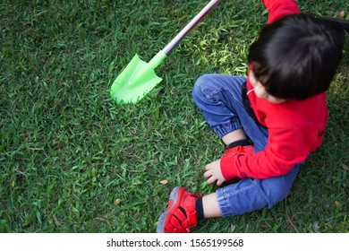 A Child Digging Soil On The Ground