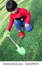 A Child Digging Soil On The Ground