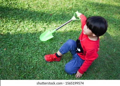 A Child Digging Soil On The Ground