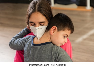 Child With Disabilities Is Hugged By Physiotherapist Wearing Protective Mask