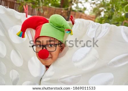 Child disguised as a jolly court jester in carnival or at the talent show in the holiday camp