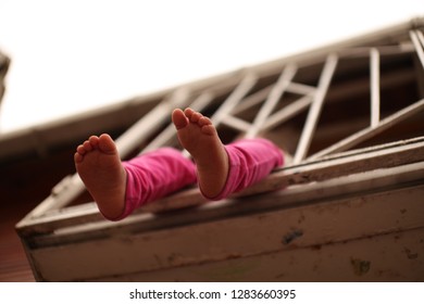 the child disturbs his feet from the balcony - Powered by Shutterstock