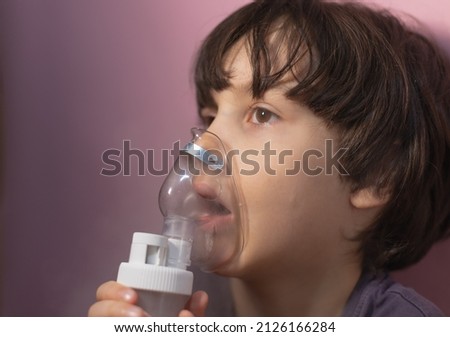 the child does inhalation, the boy inhales the medicine through the mask, nebulizer mask, treatment of the disease