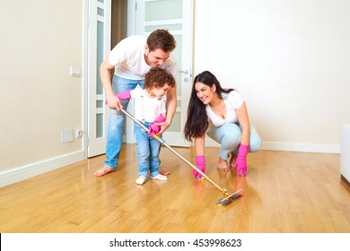 The Child Does Wet Cleaning With Mom And Dad. Children In The Family. Kid Cleans Mop The Floor In The Room With Parents. The Concept Of Family And Education Of Children.