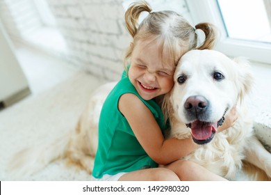 A child with a dog. Girl with a Labrador at home.  - Powered by Shutterstock