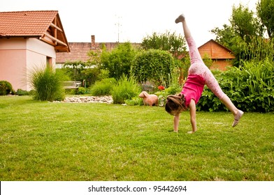 Child Doing Cartwheel In Backyard