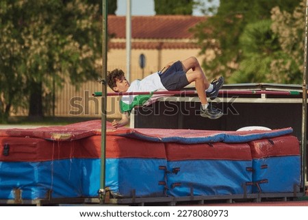 a child doing height jump during a school olympics jumping over the bar