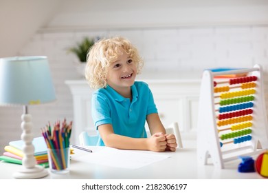 Child Doing Homework At Home. Little Boy With Wooden Colorful Abacus Doing Math Exercise Learning Addition And Counting. Kids Study And Learn. Preschooler Kid Writing And Reading. Back To School.