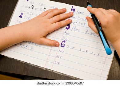 child doing homework. school task, hand writing exercise. learning to write number  names.  - Shutterstock ID 1308840607