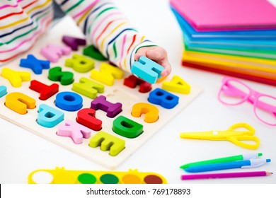 Child Doing Homework For School At White Desk. Wooden Educational Abc Toy Puzzle For Kids. Happy Back To School Student. Kid Learning Alphabet Letters. Little Girl With School Supplies And Books.