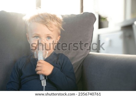 Child doing inhalations on the couch.