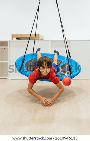 Child doing therapy exercises lying on a swinging platform