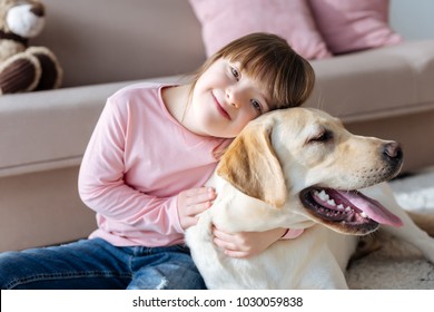 Child With Down Syndrome Cuddling With Dog