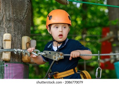 A Child With Down Syndrome Goes In For Sports On An Obstacle Course, A Child In A Helmet On A Children's Playground, Previously Developing Children.