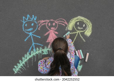 Child Drawing Family With Chalk On Asphalt, Top View