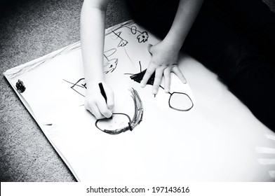 A Child Drawing People In Black And White.