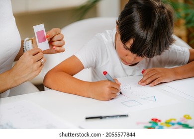 Child Drawing Shapes In A Preschooler Assessment Test. Psychologist Helping Him.