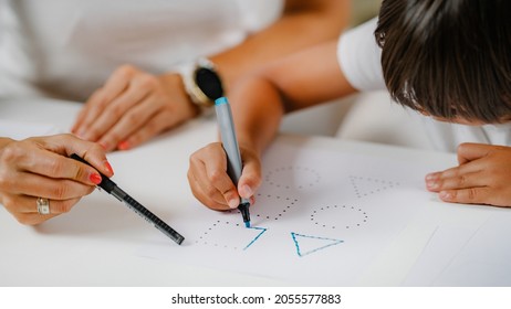 Child Drawing Shapes In A Preschooler Assessment Test. Psychologist Helping Him.