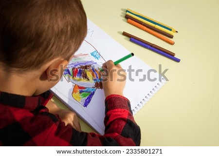 A child draws an abstract drawing 
