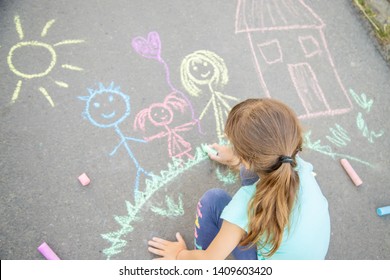 Child draws a family on the pavement with chalk. Selective focus. nature. - Powered by Shutterstock